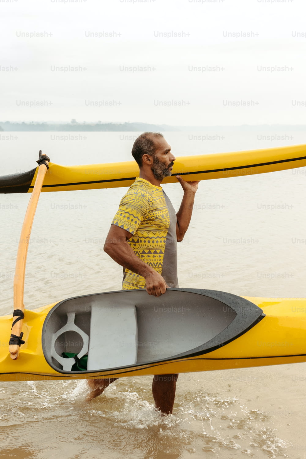 Un uomo che trasporta un kayak fuori dall'acqua