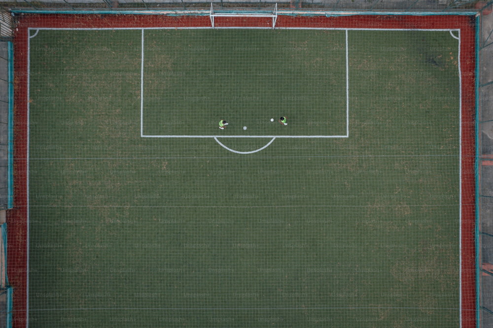 Vista aérea de um campo de futebol com dois jogadores
