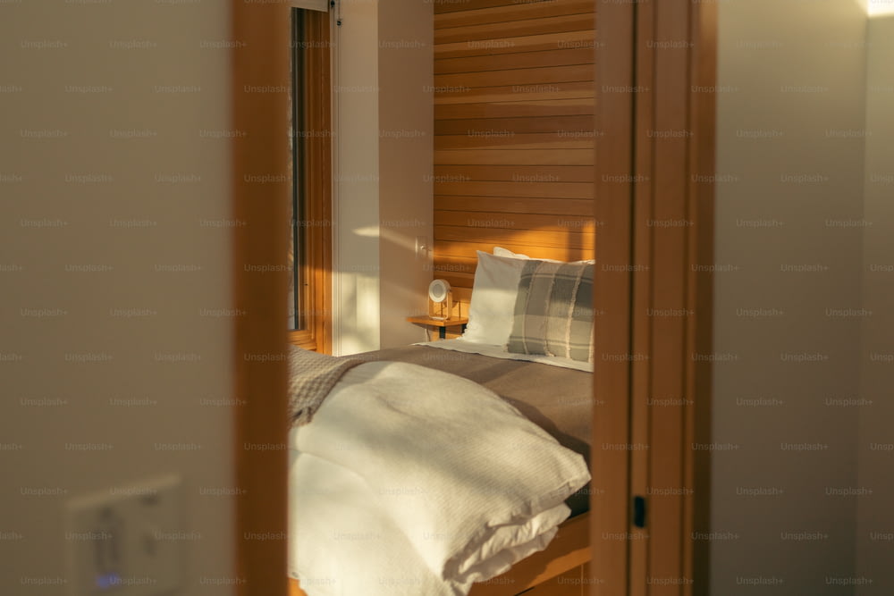 ein Bett, das in einem Schlafzimmer neben einer Holztür steht