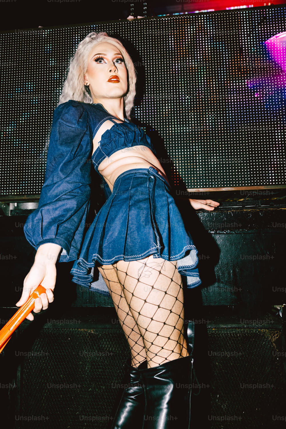 a woman in a blue dress and fishnet stockings