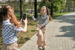 Dos niñas están jugando con un teléfono celular