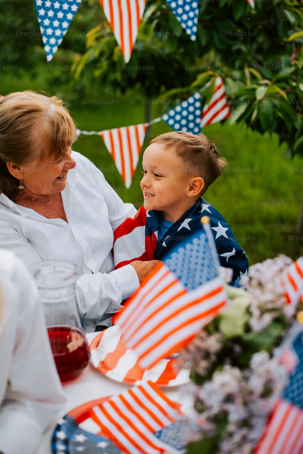 Eine Frau und ein Kind, die an einem Tisch mit amerikanischen Flaggen sitzen