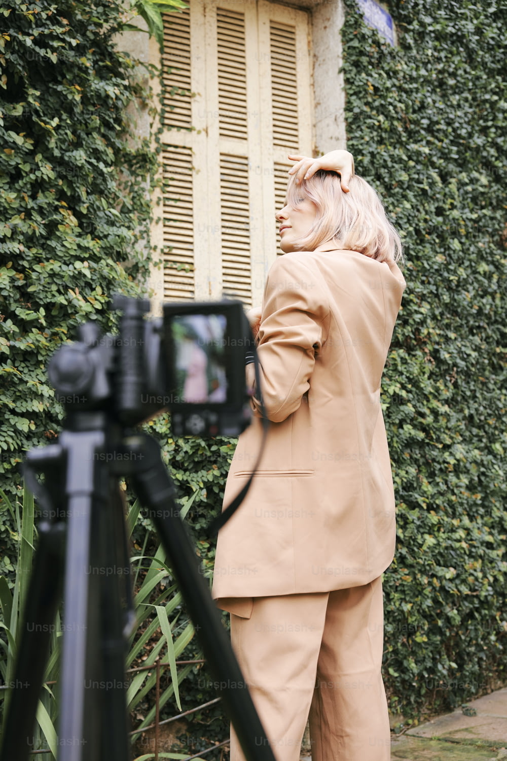 Una mujer parada frente a una cámara tomando una foto