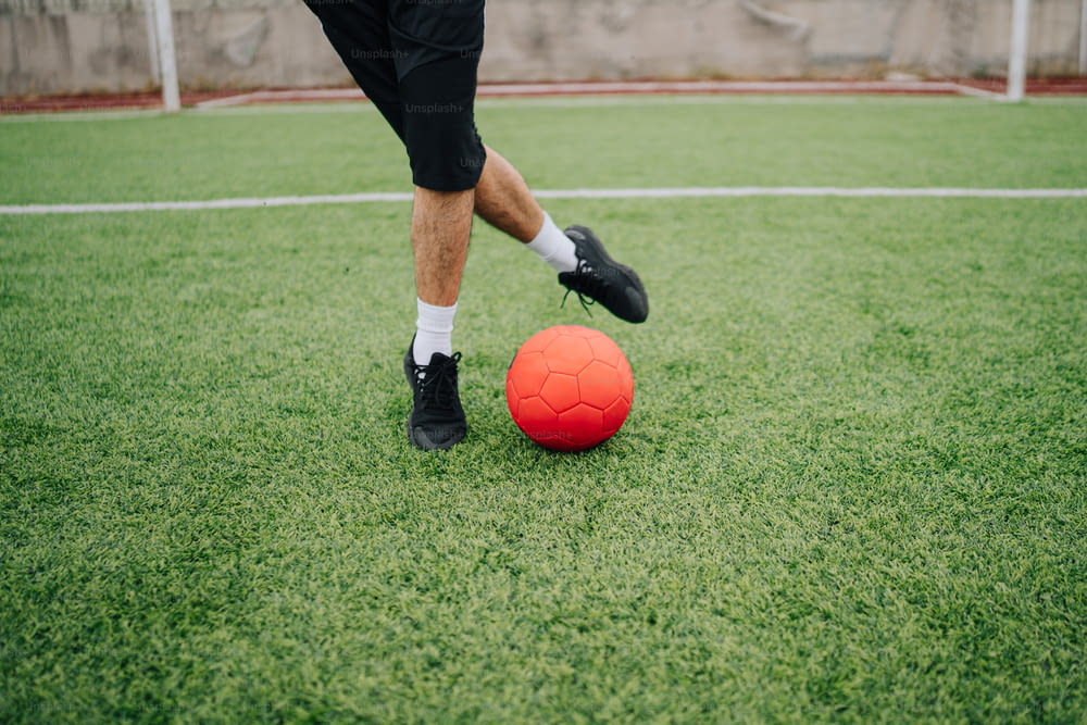 a man kicking a soccer ball on a soccer field