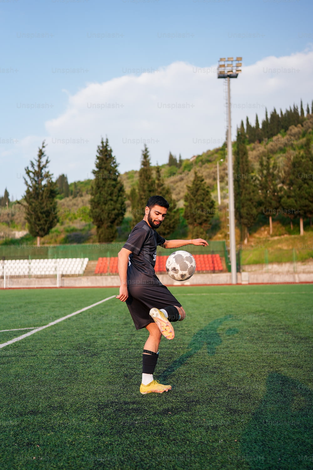 Un uomo che calcia un pallone da calcio su un campo