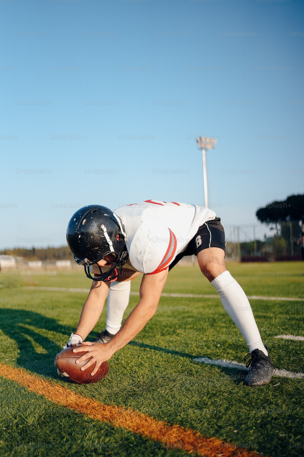 a football player kneeling down to pick up a ball