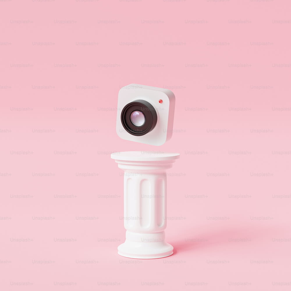 a small camera sitting on top of a white pedestal