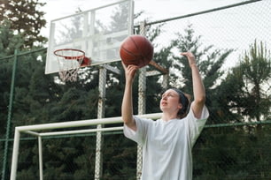 a young man holding a basketball up in the air