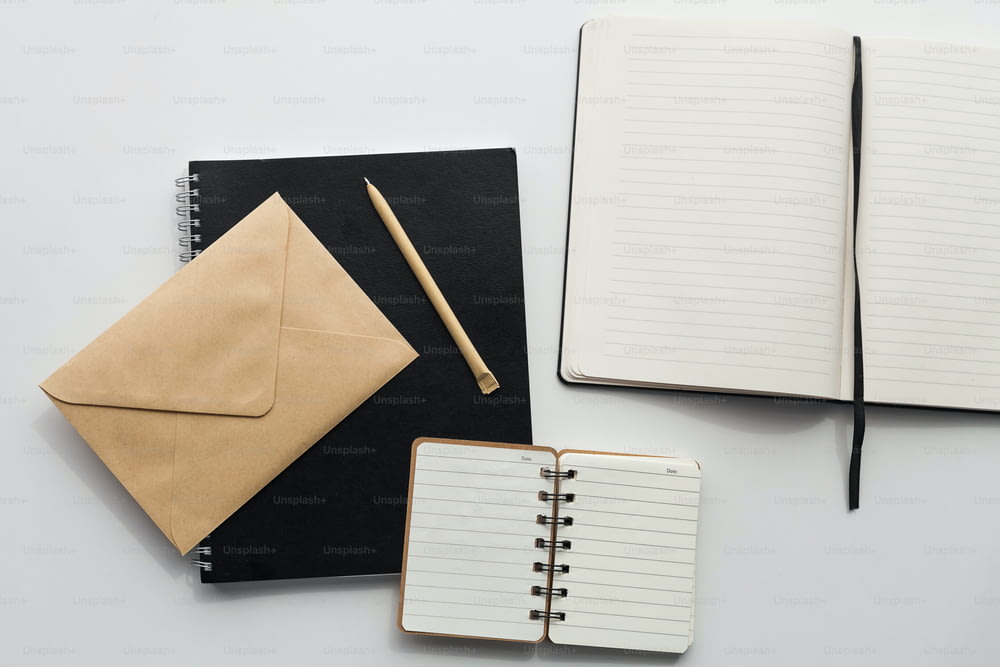 ein Notizbuch, einen Stift und einen Umschlag auf einem Tisch