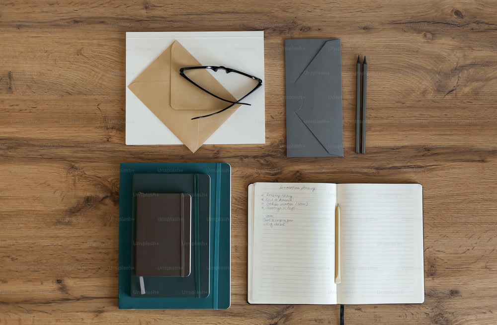 Notizblock, Stift, Notizbuch und Papier auf einem Holztisch