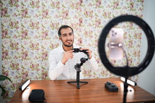 Un hombre sentado en un escritorio con una cámara