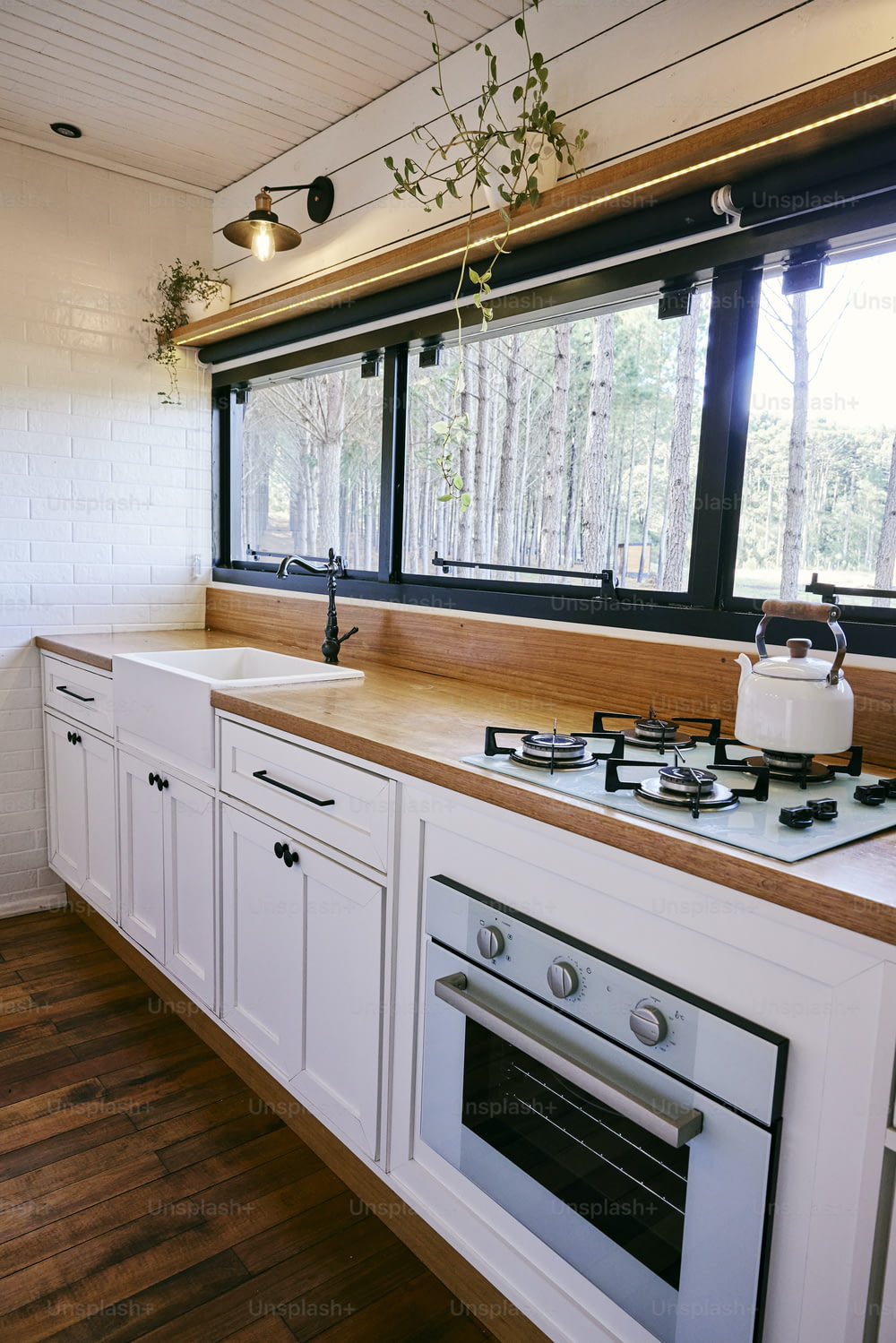 uma cozinha com fogão, forno e janela;