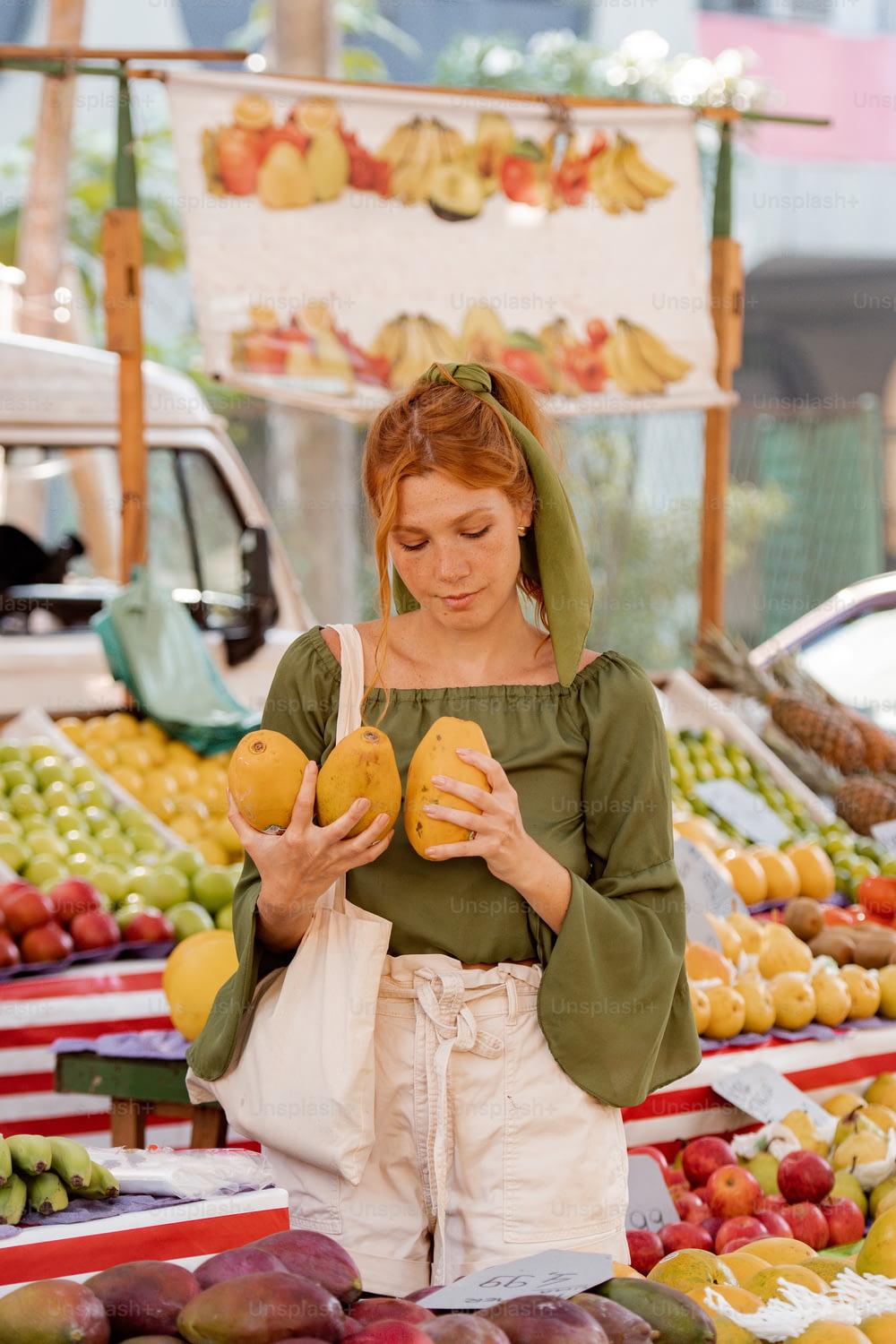果物のディスプレイの前に立つ女性