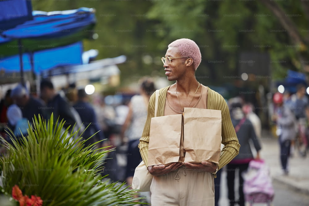 a man with a bald head holding a paper bag