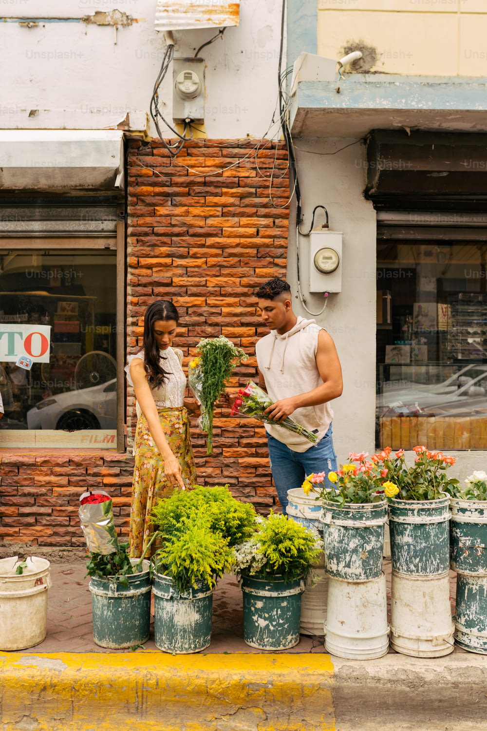 Un homme et une femme debout devant un fleuriste