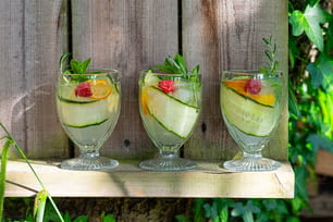 three glasses filled with different types of fruit