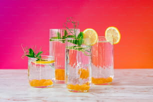 drei Glasvasen, gefüllt mit Zitronen und Wasser