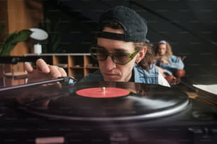 Un homme avec un chapeau et des lunettes de soleil jouant un disque