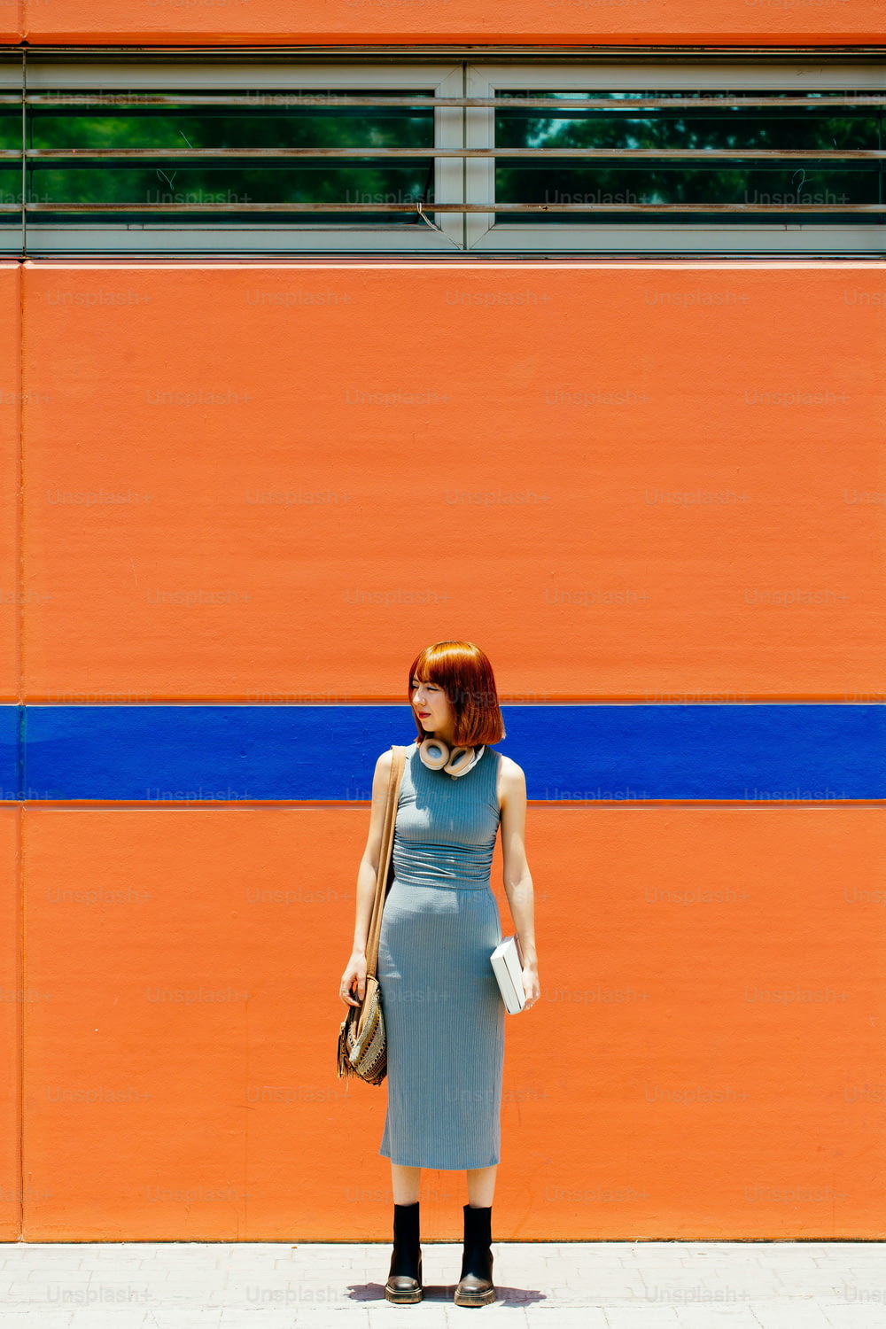 a woman standing in front of an orange wall