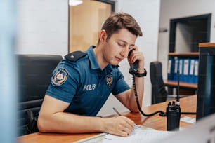 책상에 앉아 전화 통화를 하는 경찰관