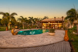 uma casa com piscina rodeada por palmeiras