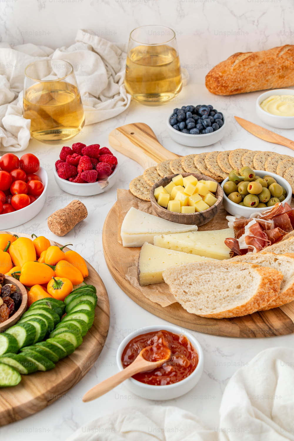 a platter of cheese, fruit, and bread on a table