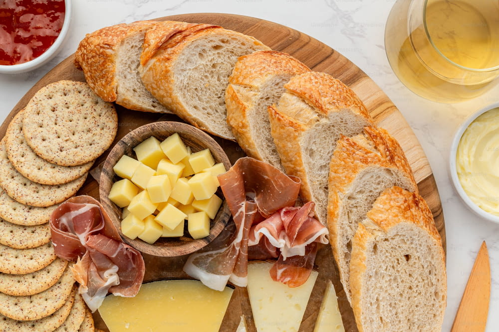 a platter of bread, cheese, crackers, and meats