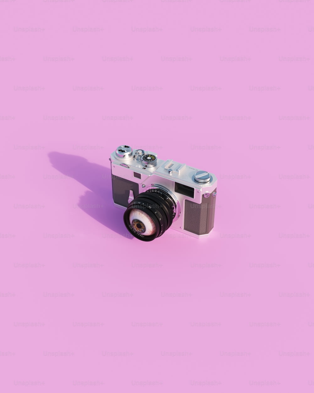 a camera on a pink background with a lens