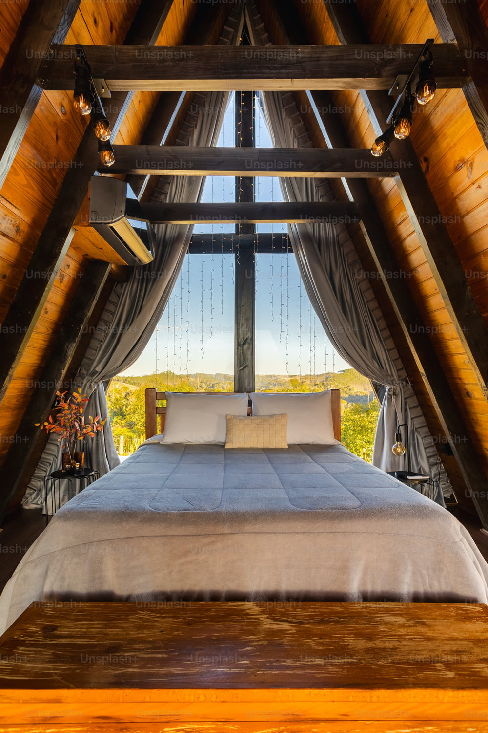 a bed in a room with a wooden ceiling
