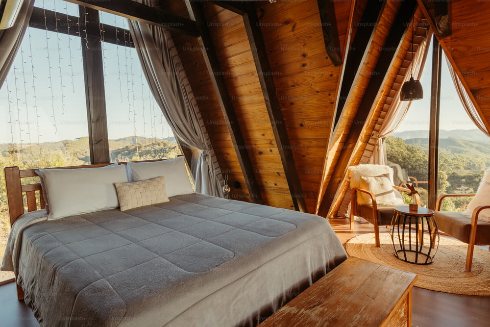 una cama en un dormitorio con vistas a las montañas