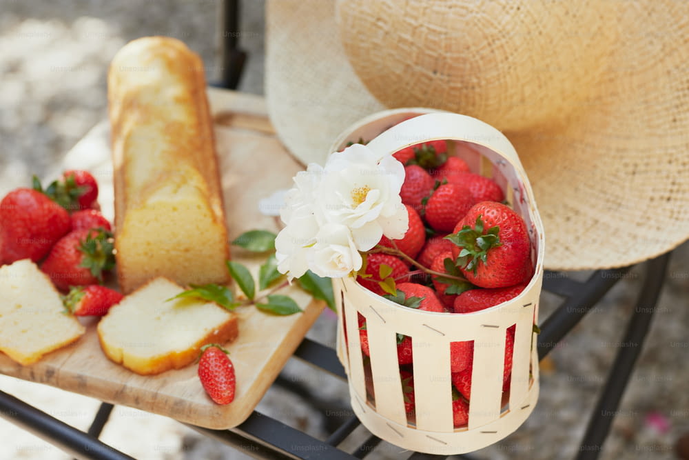 a basket of strawberries and sliced bread on a table