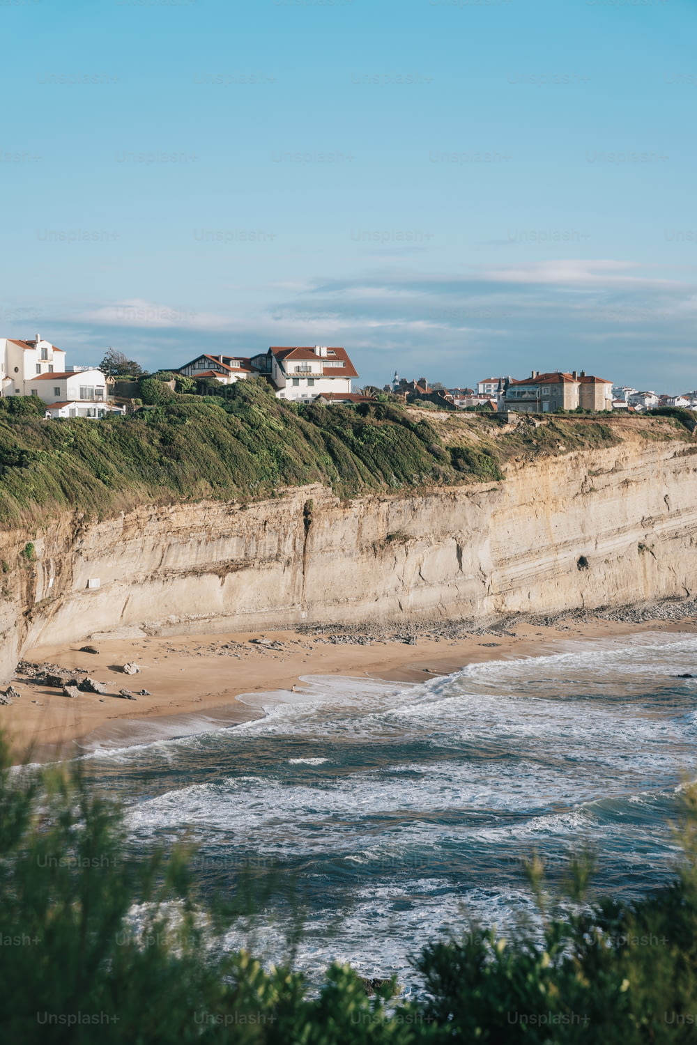 une vue d’une plage avec des maisons sur la falaise