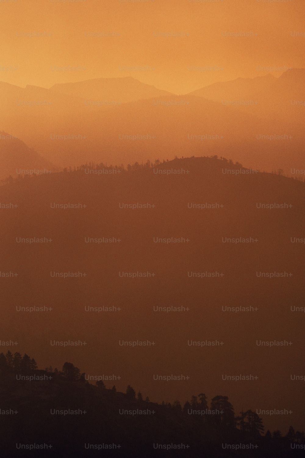 a hazy view of a mountain range with trees