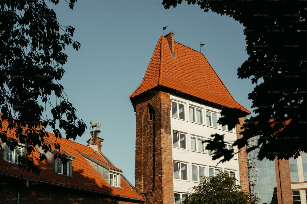 a tall building with a red roof and a clock tower