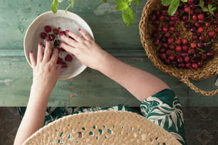 una persona sosteniendo un plato con cerezas