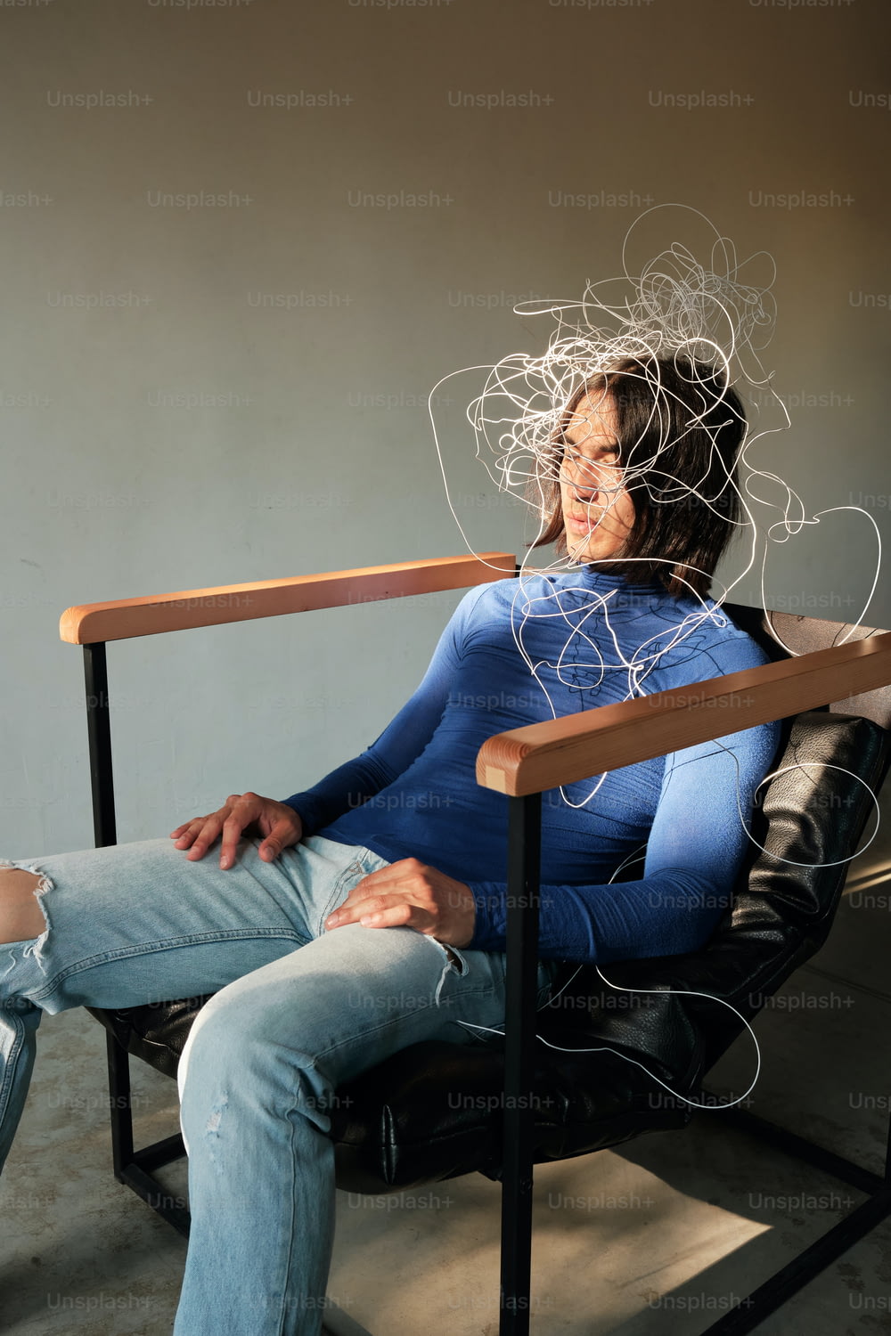 Une femme assise sur une chaise avec des fils sur la tête