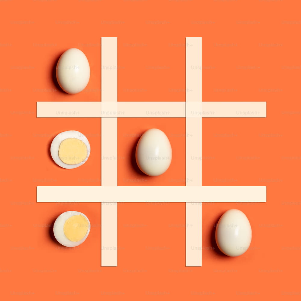 a tic - tac - toe game with eggs on an orange background