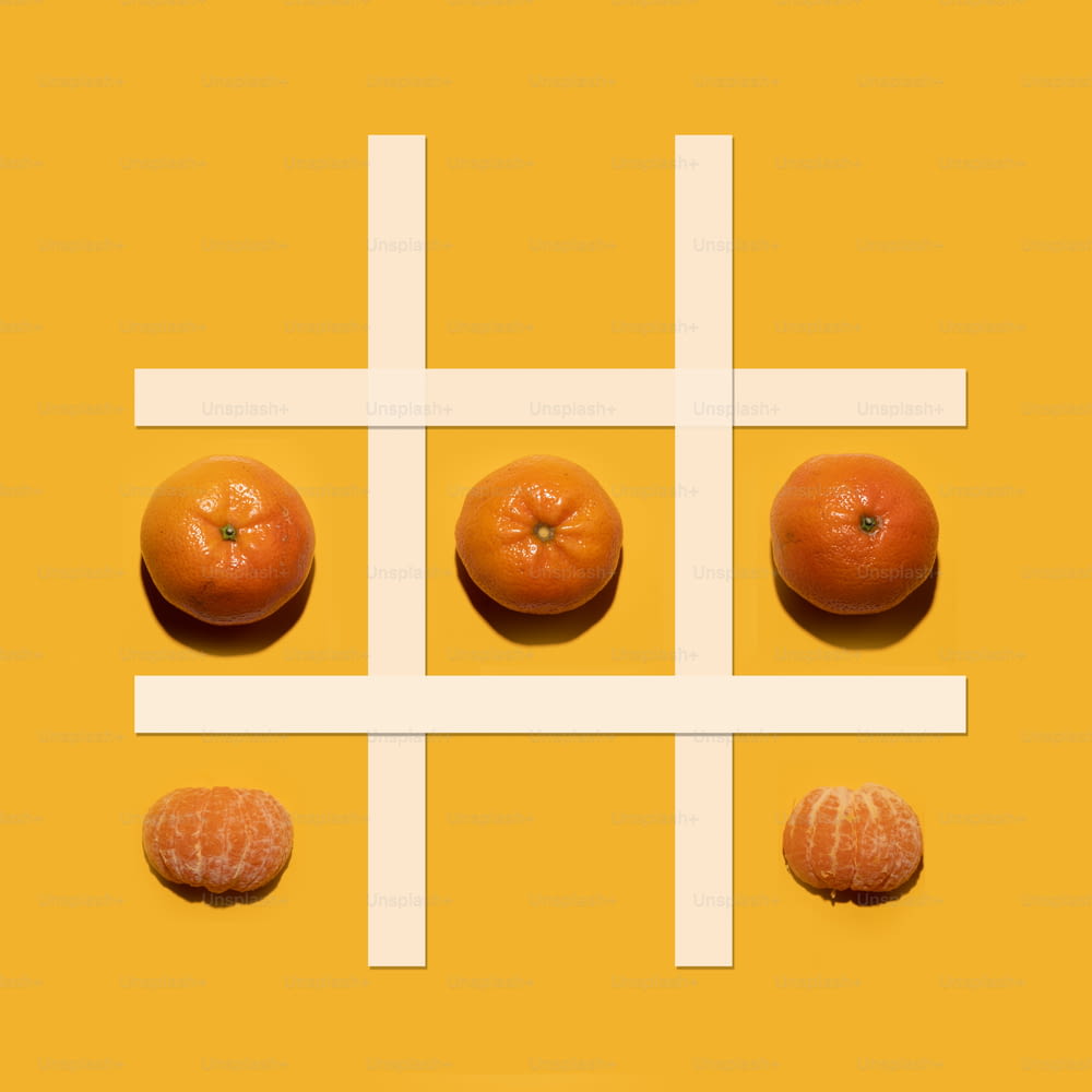 um grupo de laranjas sentado em cima de uma superfície amarela