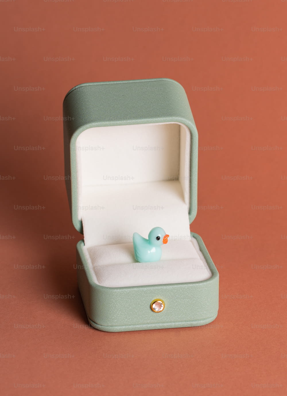 um pequeno pato de borracha azul em uma caixa verde