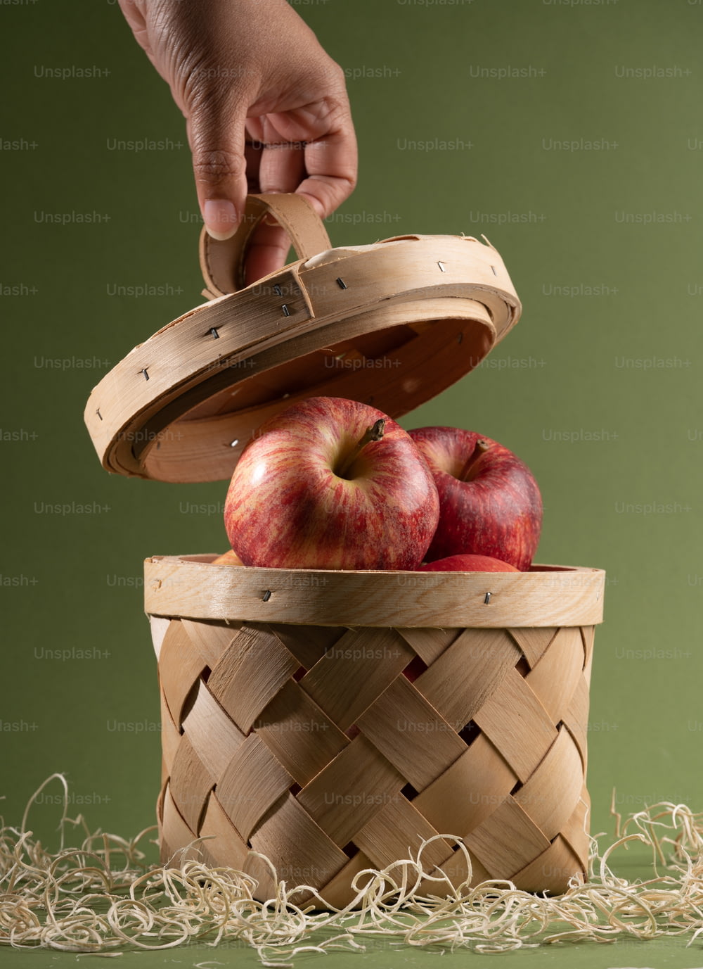 Una persona poniendo una manzana en una canasta