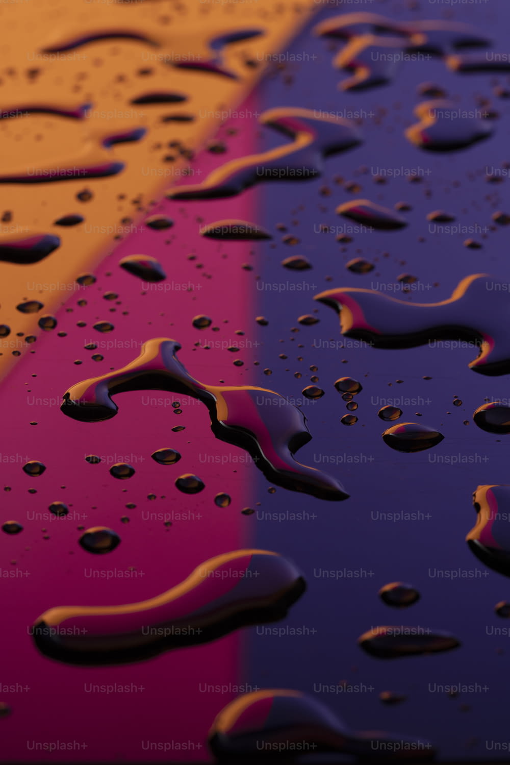 a close up of water droplets on a colorful surface