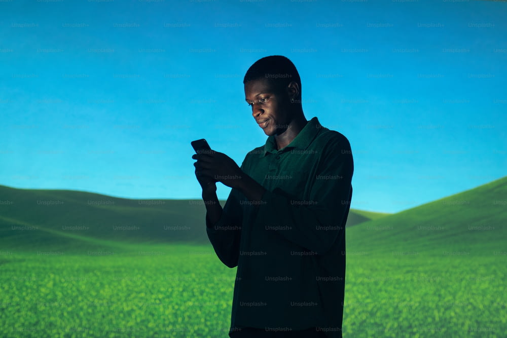 a man standing in front of a screen holding a cell phone