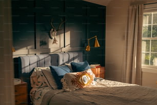 a bed in a bedroom with a deer head on the wall