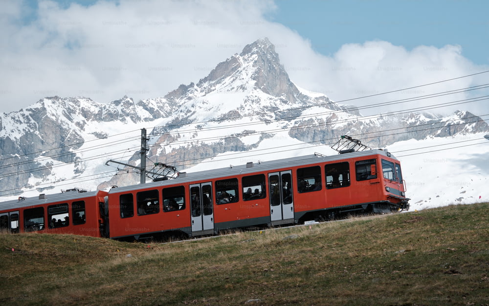 雪に覆われた山を通り過ぎる赤い列車
