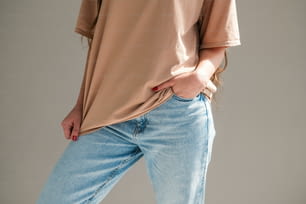 a woman wearing a tan shirt and blue jeans