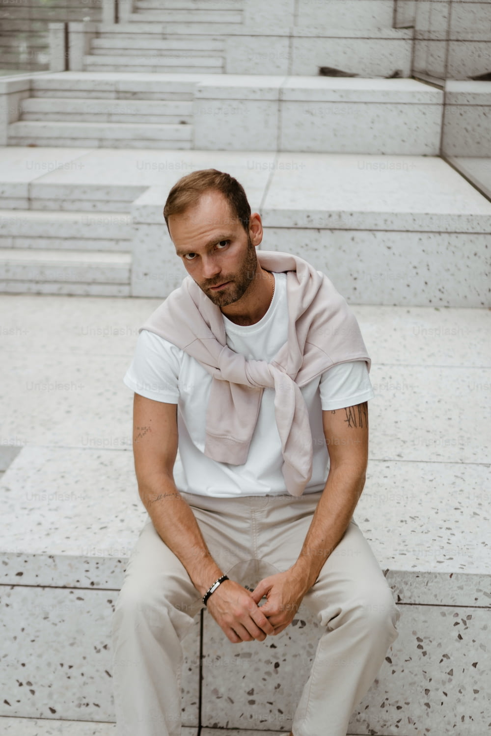 a man sitting on steps with a scarf around his neck