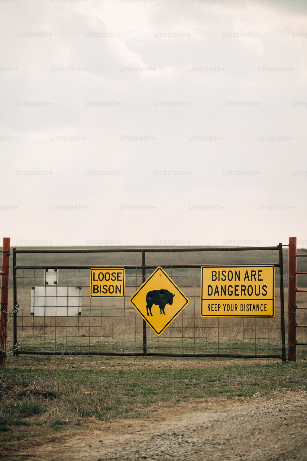 una recinzione con un cartello che dice che i bisonti sono pericolosi