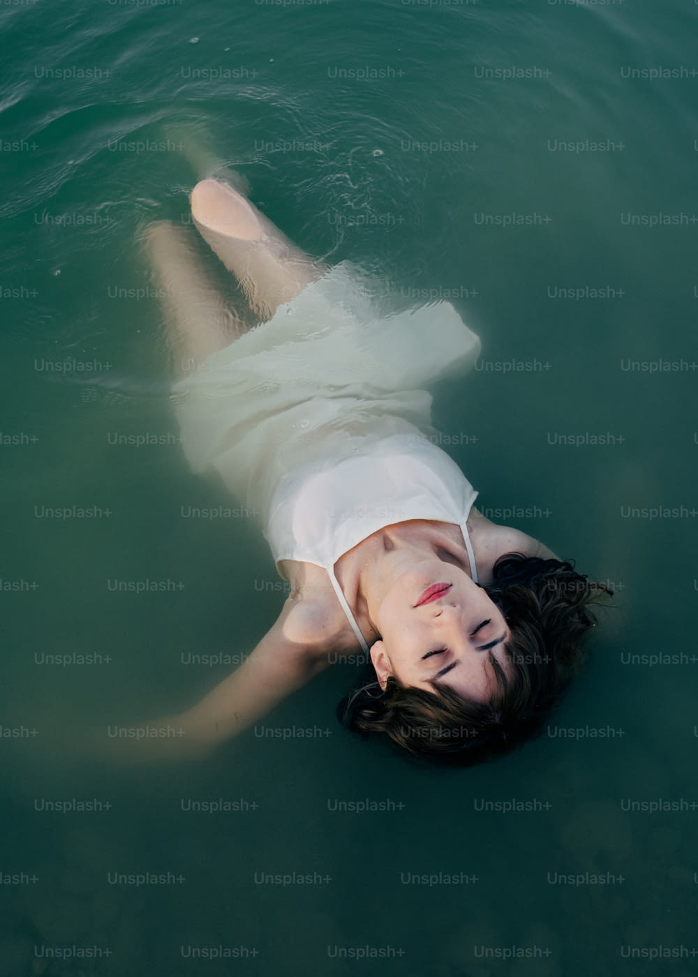 Una mujer acostada boca arriba en el agua
