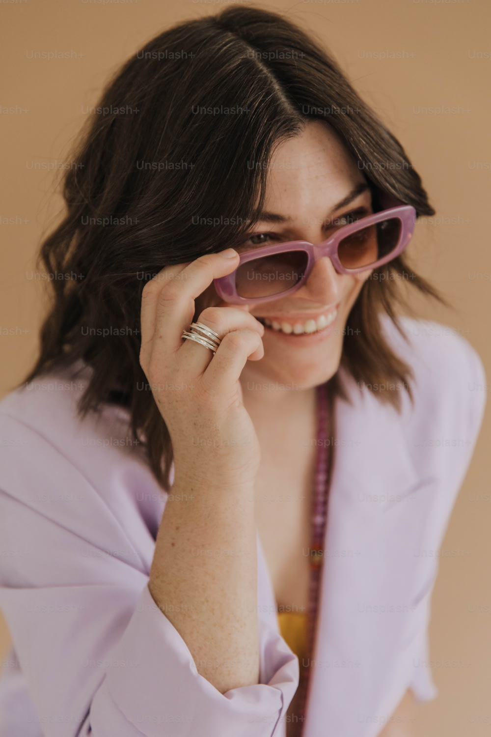 a woman in a purple shirt holding a pair of sunglasses