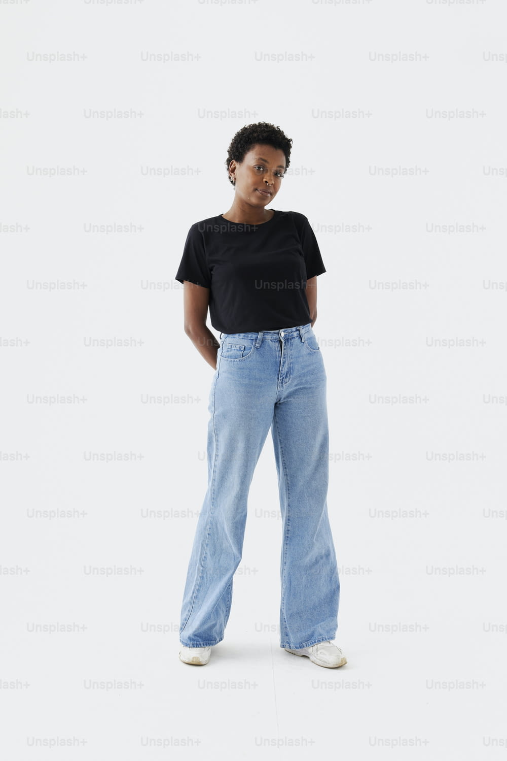 uma mulher em uma t-shirt preta e jeans azul claro